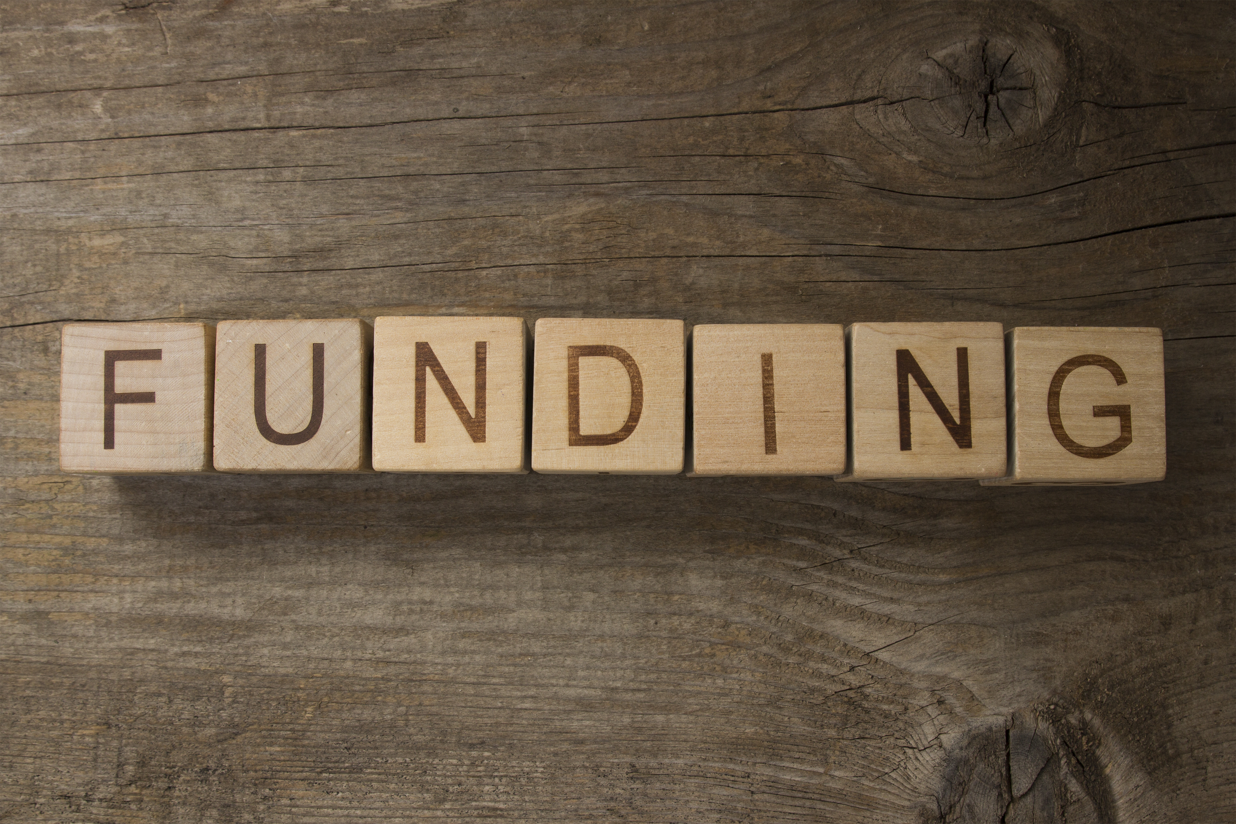 text FUNDING on a wooden background